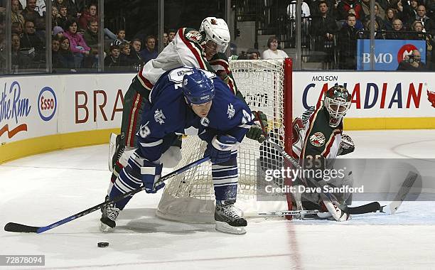 Manny Fernandez of the Minnesota Wild slides into position as Mats Sundin of the Toronto Maple Leafs attempts a wrap-around and Kim Johnsson of the...