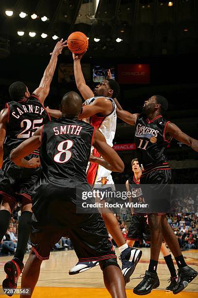 Ike Diogu of the Golden State Warriors shoots against Rodney Carney, Joe Smith and Bobby Jones of the Philadelphia 76ers on December 26, 2006 at...