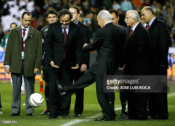 Peace Nobel Prize laureate and Deputy Prime Minister of Israel Simon Peres shoots the ball supported by France's football legend Michel Platini prior...