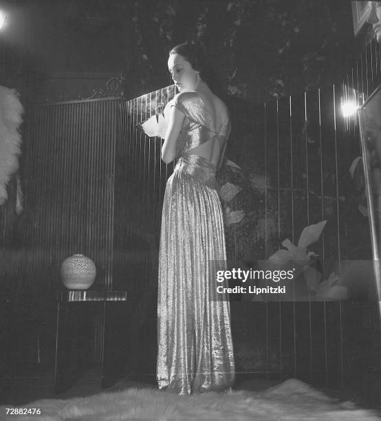 Fashion model wears an evening gown designed by French fashion designer Jeanne Lanvin, Paris, February 1935.