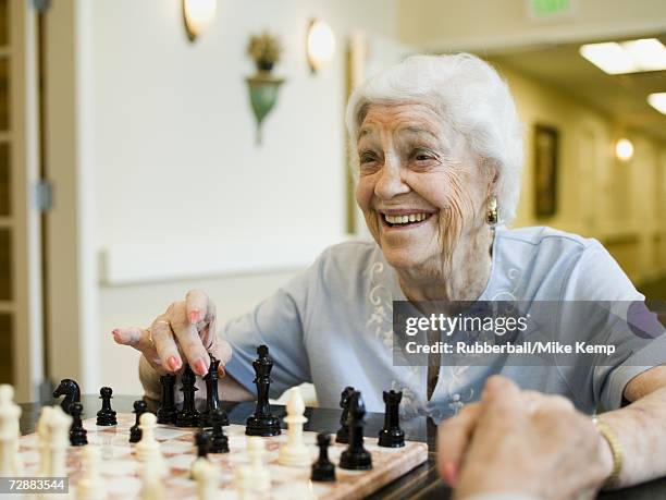 elderly woman playing chess - senior playing chess stock pictures, royalty-free photos & images