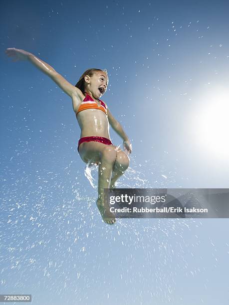 young girl jumping in water - young girl jumping into swimming pool stock pictures, royalty-free photos & images