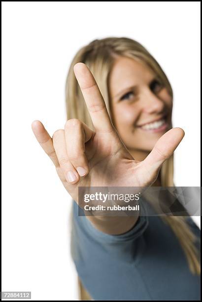 woman making the i love you sign - love you stockfoto's en -beelden