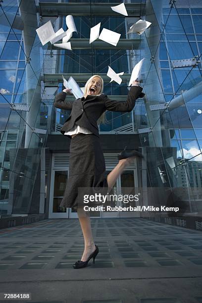 businesswoman tossing papers in the air - mike glad stock-fotos und bilder
