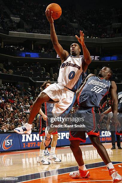 Gilbert Arenas of the Washington Wizards shoots over Emeka Okafor of the Charlotte Bobcats on December 27, 2006 at the Charlotte Bobcats Arena in...