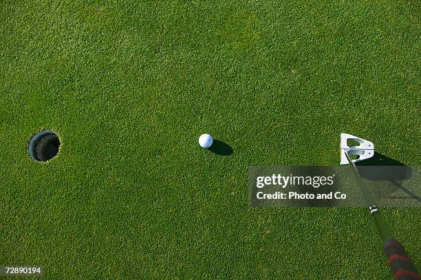 golf ball and putter on green near hole at golf course - golf ball hole stock pictures, royalty-free photos & images