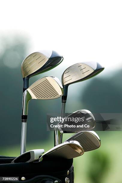 golf clubs in bag at golf course, close-up - golfclub stockfoto's en -beelden