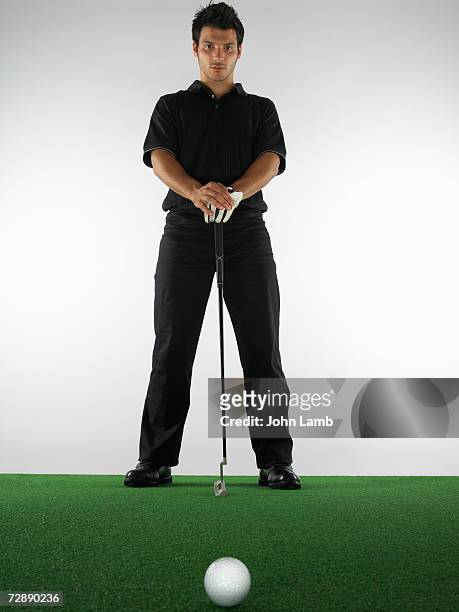 male golfer with putter standing on green - golf club on white stock pictures, royalty-free photos & images
