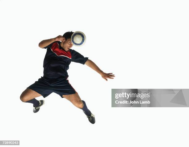 footballer heading ball in mid-air - heading the ball ストックフォトと画像