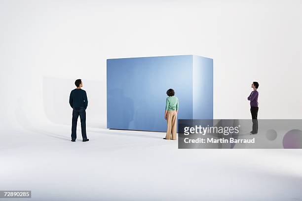 woman with two men beside giant box - sehen stock-fotos und bilder