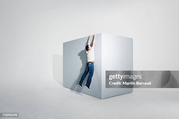 man assisting colleague climbing on giant box - grab stock pictures, royalty-free photos & images