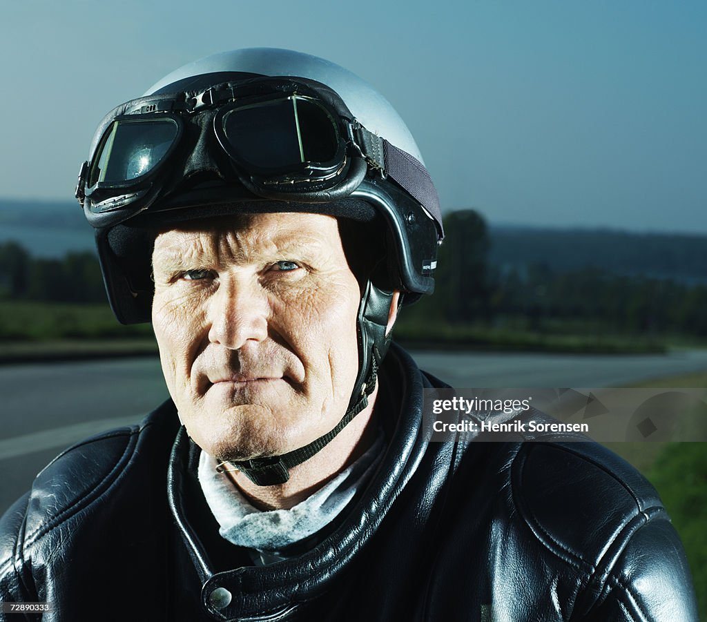 Mature man wearing motorcycle helmet, portrait
