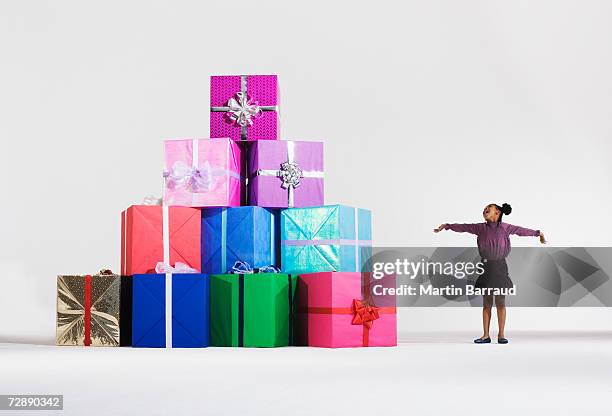 girl (6-7) standing by stack of giant presents - pile of gifts stock pictures, royalty-free photos & images