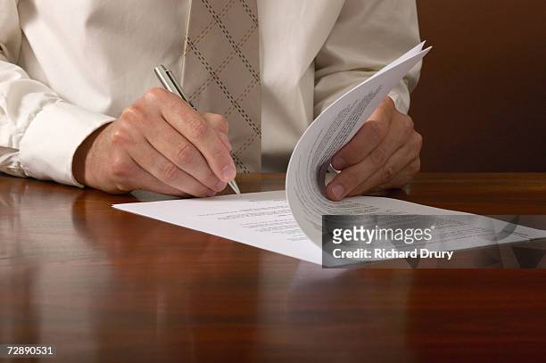businessman signing papers on desk, close up, close-up - documento foto e immagini stock