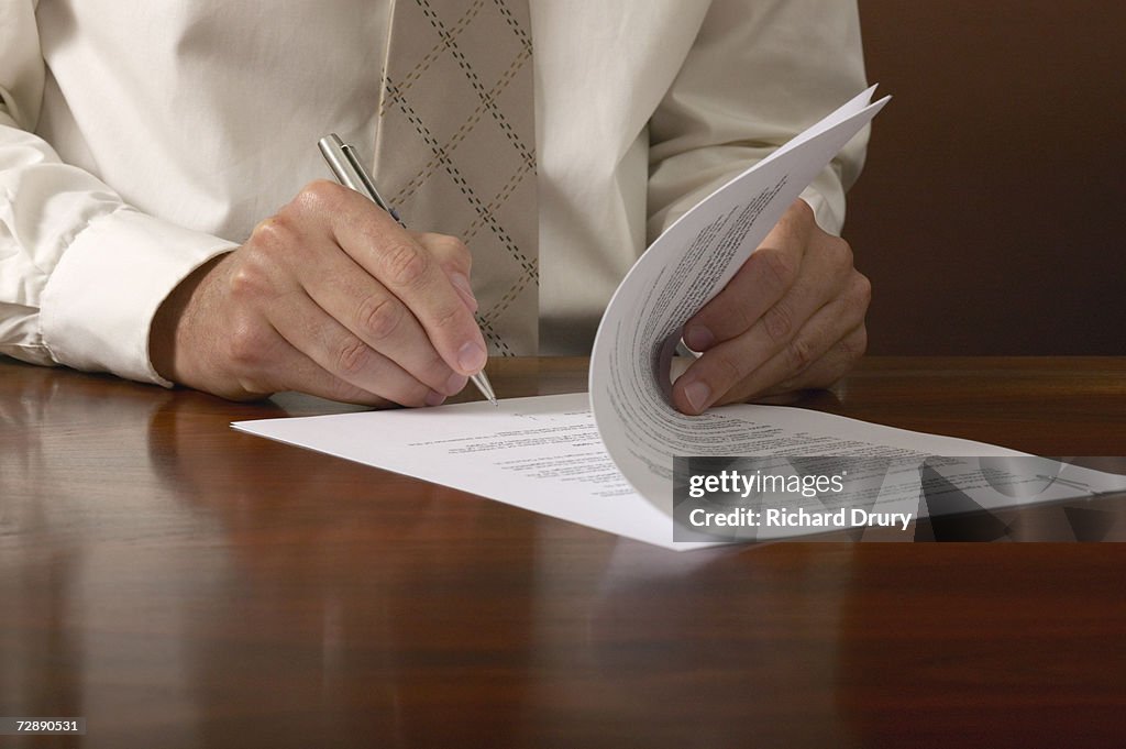 Businessman signing papers on desk, close up, close-up