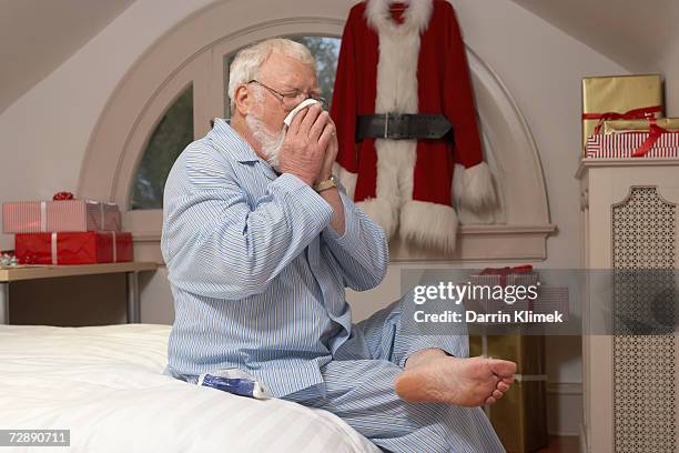father christmas sittin on bed, blowing nose - sole ストックフォトと画像