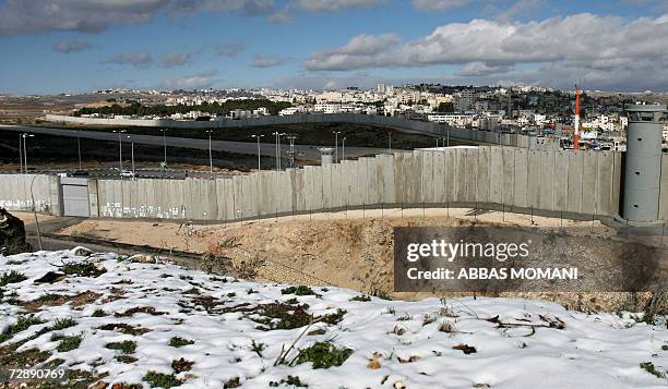 The Israeli built controversial separation barrier is seen cutting through the land behind which is the palestinian refugee camp of Kalandia several...