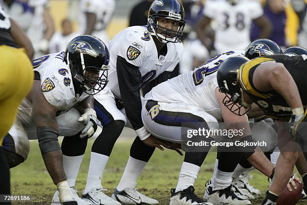Quarterback Steve McNair of the Baltimore Ravens looks up before taking the ball from center Mike Flynn as offensive lineman Keydrick Vincent...