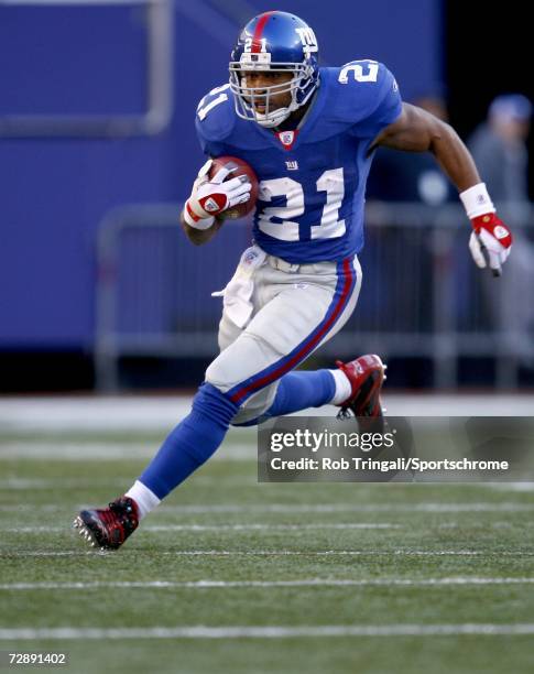 Running Back Tiki Barber of the New York Giants runs with the ball against the New Orleans Saints on December 24, 2006 at Giants Stadium in East...