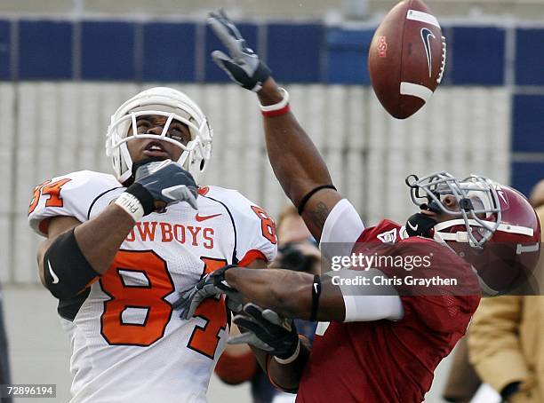 Juan Woods of Oklahoma State fights for a ball with Ramzee Robinson of Alabama on December 28, 2006 during the PetroSun Independence Bowl at...