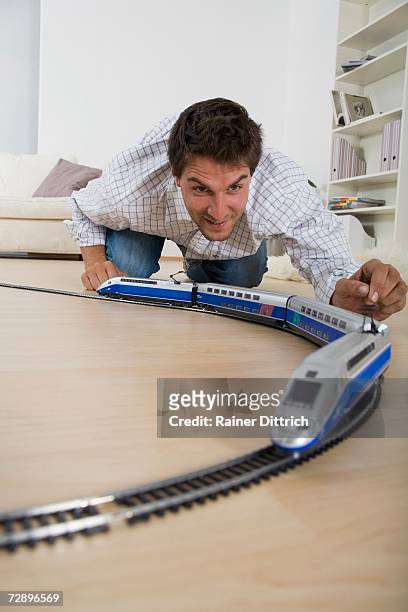 man playing with toy train, close-up - model train stock pictures, royalty-free photos & images