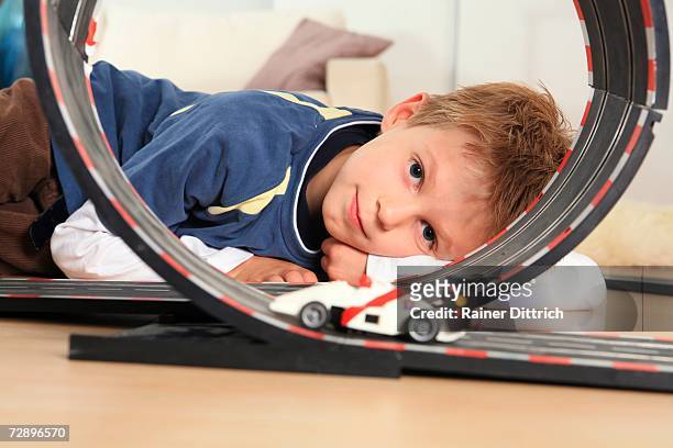 boy (6-7) playing with toy racetrack, close-up - toy car foto e immagini stock