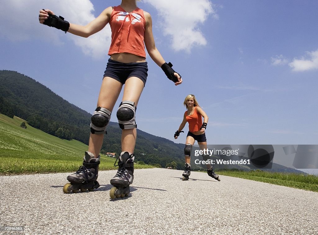 Two teenage girls (13-15) inline skating