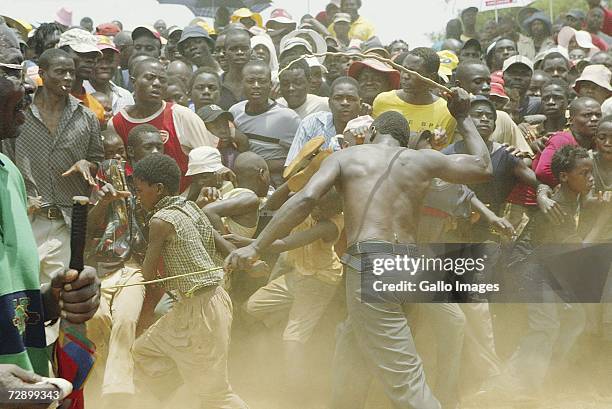 Mashall hits the crowds to move them back to make space for the fighters during a traditional fist fighting match on December 29, 2006 in Tshaulu...