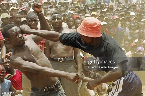 Gpina hits Makangari during a traditional fist fighting match on December 29, 2006 in Tshaulu Village, Venda, South Africa. Local people take part in...