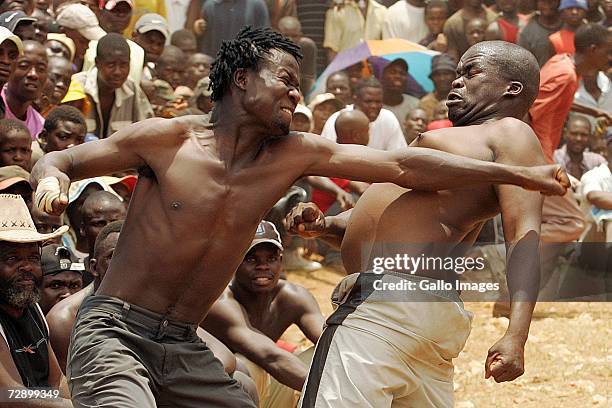 Micheal hits Isaac during a traditional fist fighting match on December 29, 2006 in Tshaulu Village, Venda, South Africa. Local people take part in...