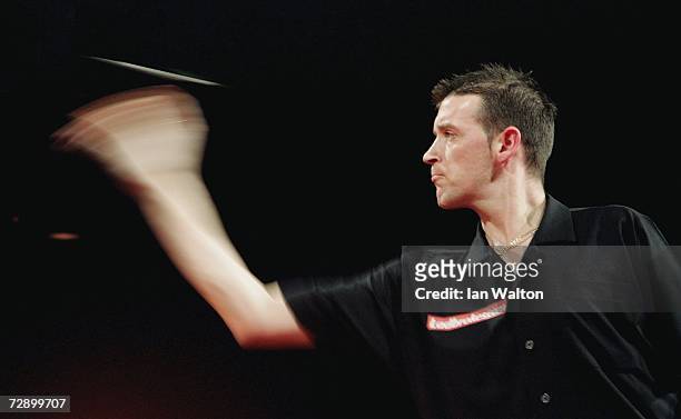 Colin Osborne of England throws against Andy Jenkins of England during the quarter-finals of the Ladbrokes World Darts Championship at The Circus...