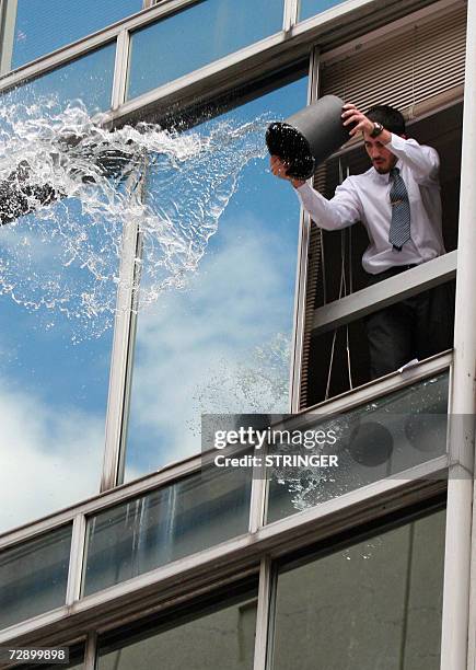 Un oficinista lanza agua a transeuntes desprevenidos en la Ciudad Vieja de Montevideo el 29 de diciembre de 2006. Los oficinistas de la Ciudad Vieja...