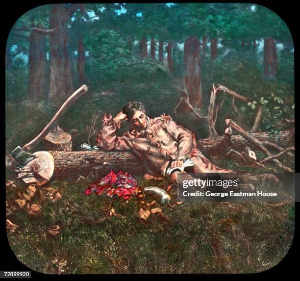 Image shows American President Abraham Lincoln as a young man as he reads a book and leans against a felled tree, early 1800s. The image was...