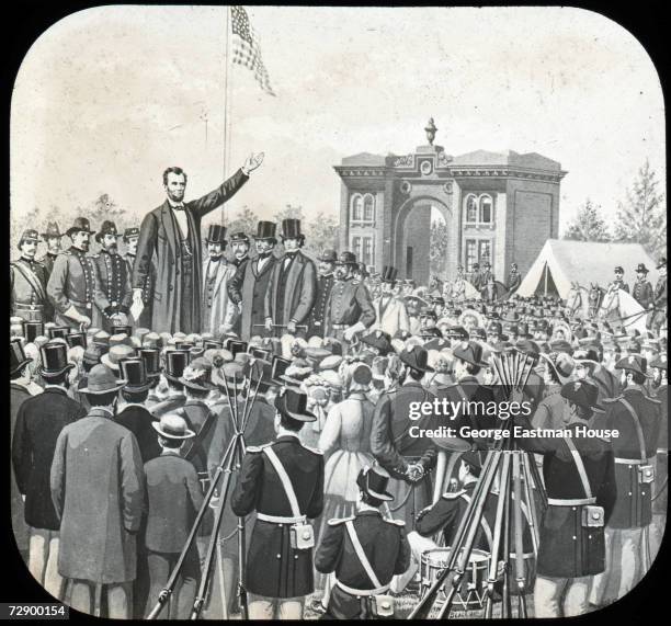 American President Abraham Lincoln raises his hand as he delivers the speech later known as the 'Gettysburg Address' to a large audience, Gettysburg,...