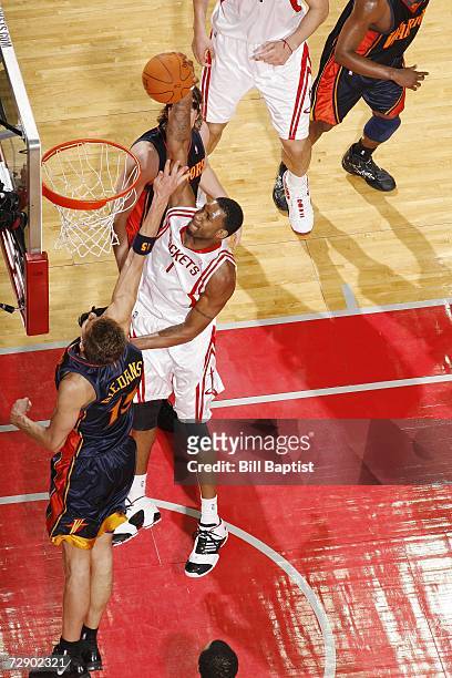 Tracy McGrady of the Houston Rockets powers the ball to the hoop past Andris Biedrins of the Golden State Warriors at the Toyota Center on December...