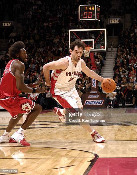 Jorge Garbajosa of the Toronto Raptors drives hard around Ben Wallace of the Chicago Bulls on December 29, 2006 at the Air Canada Centre in Toronto,...
