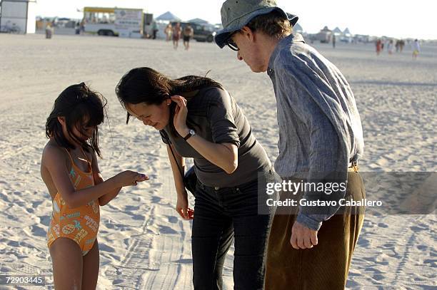 Woody Allen and wife Soon Yi Previn look at something their daughter Bechet found on the beach on December 29, 2006 in Miami Beach , Florida.