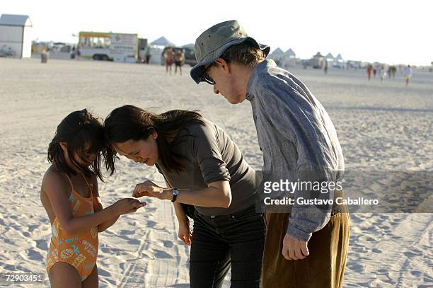 Woody Allen and wife Soon Yi Previn look at something their daughter Bechet found on the beach on December 29, 2006 in Miami Beach , Florida.