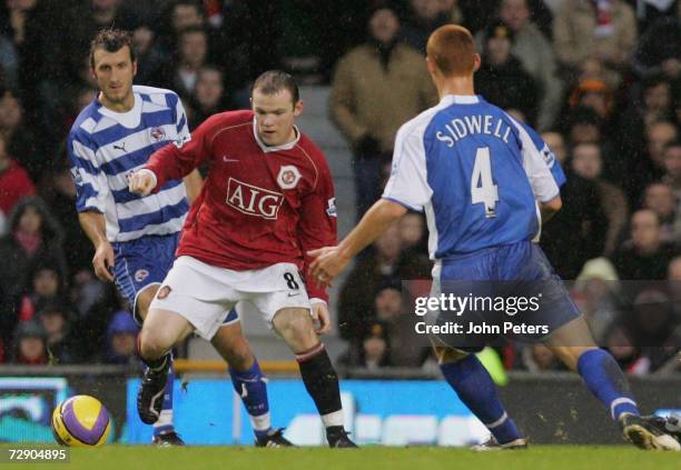 Wayne Rooney of Manchester United clashes with Glen Little and Steven Sidwell of Reading during the Barclays Premiership match between Manchester...