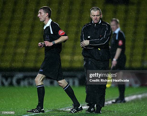 Referee Steve Tanner and 4th official Graham Poll talk on the side lines then agree to make the players leave the pitch due to adverse conditions...