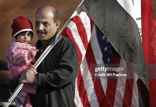 Iraqi Americans Riyadh Musa and his 13 month-old daughter Zinib of Detroit, Michigan attend a rally to celebrate the execution of former Iraqi leader...