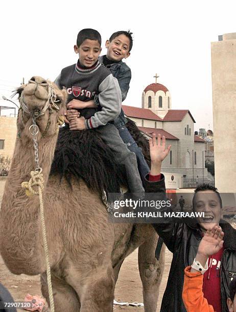 Jordanian Muslim children enjoy a camel ride at one of the popular neighborhoods in eastern Amman on the second day of Eid al-Adha, 31 December 2006....