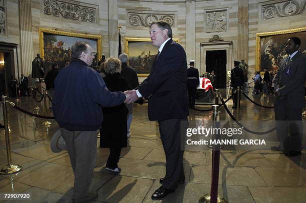 Washington, UNITED STATES: Jack Ford, son of US President Gerald R. Ford, greets mourners before his father's casket in the Rotunda of the US Capitol...