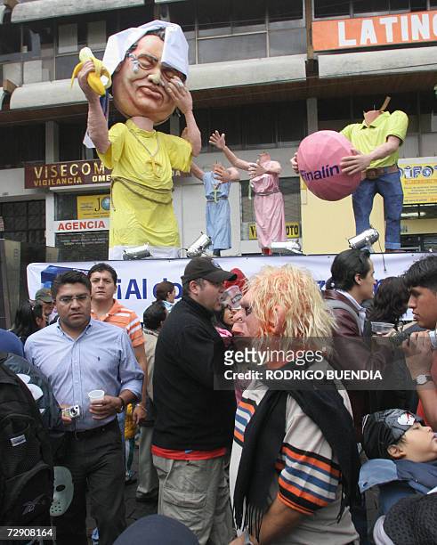 Un grupo de personas miran munecos representando personajes politicos en una calle del centro de Quito el 31 de diciembre de 2006. La tradicion de...