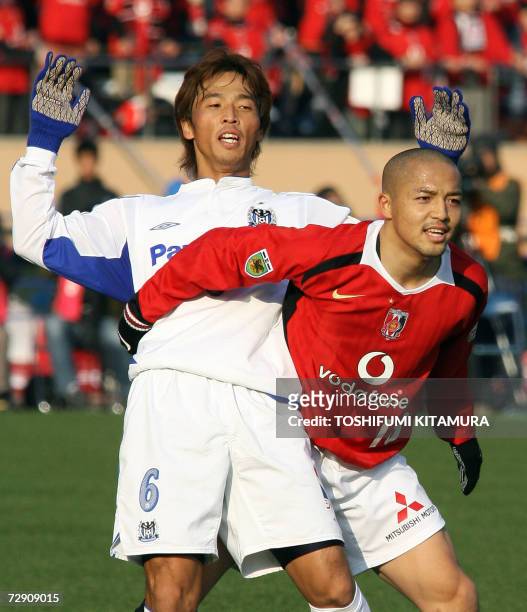 Urawa Reds midfielder Shinji Ono holds Gamba Osaka captain and defender Satoshki Yamaguchi during the 86th Emperor's Cup final match in Tokyo 01...