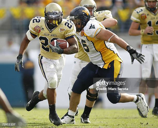 Running back Tashard Choice of the Georgia Tech Yellow Jackets runs through nose tackle Keilen Dykes of the West Virginia Mountaineers defense in the...
