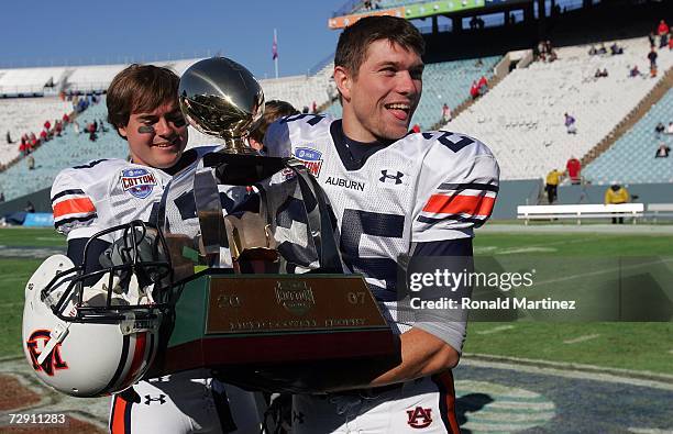 Wide receiver Lee Guess of the Auburn Tigers walks off the field with the AT&T Cotton Bowl Classic trophy after a 17-14 win against the Nebraska...