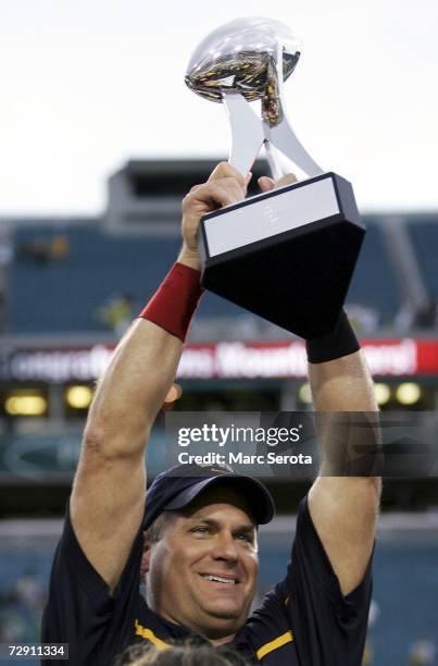 Head coach Rich Rodriguez of the West Virginia Mountaineers holds up the trophy after defeating the Georgia Tech Yellow Jackets 38-35 in the Toyota...