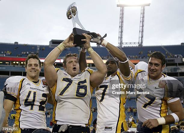 Jay Henry, Dan Mozes, Brandon Myles and Tim Lindsey of the West Virginia Mountaineers holds up the trophy after defeating the Georgia Tech Yellow...