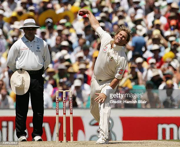 Shane Warne of Australia bowls watched by umpire Aleem Dar during day two of the fifth Ashes Test Match between Australia and England at the Sydney...